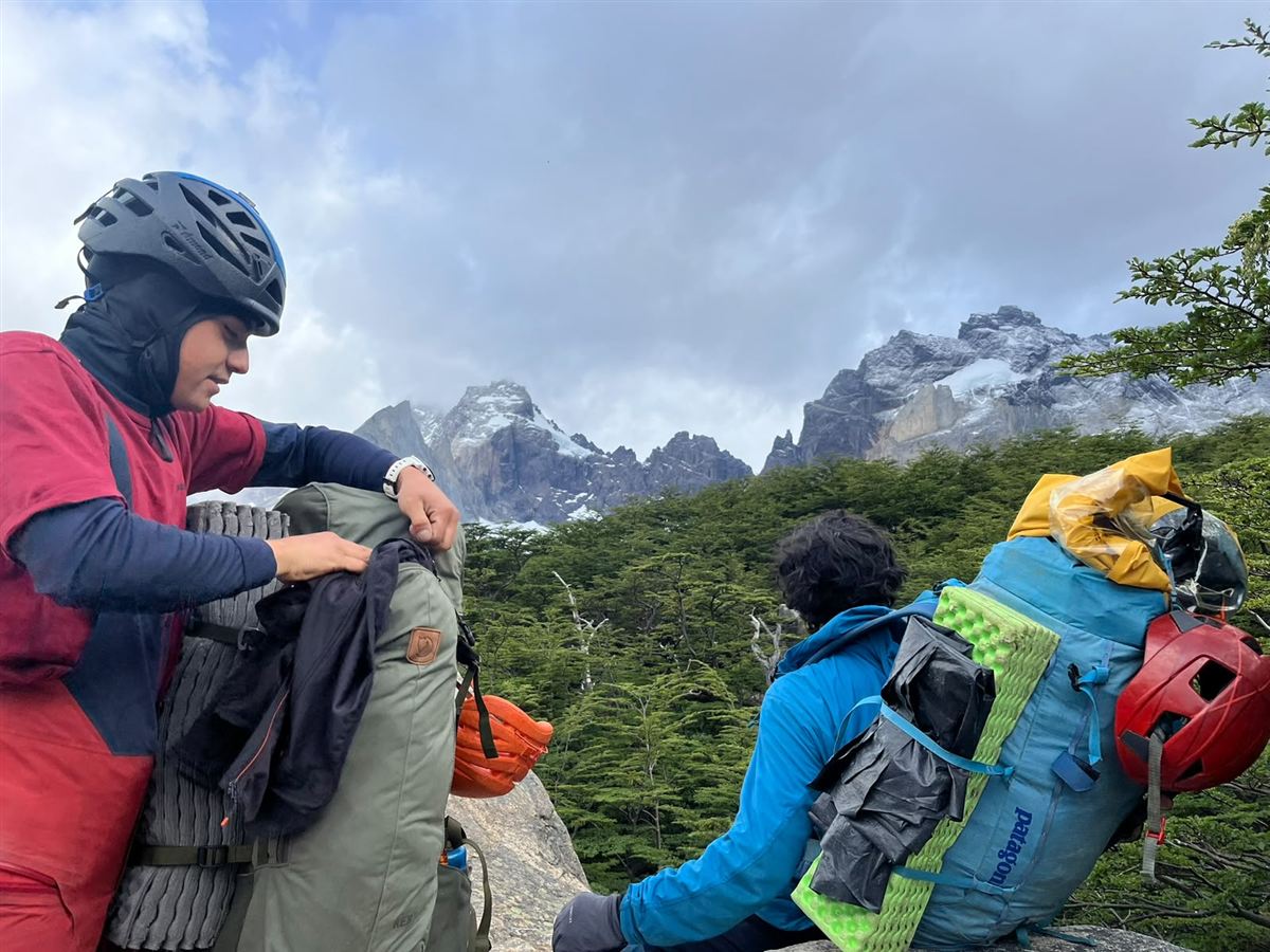 Grupo reducido preparando mochilas frente a los Cuernos del Paine