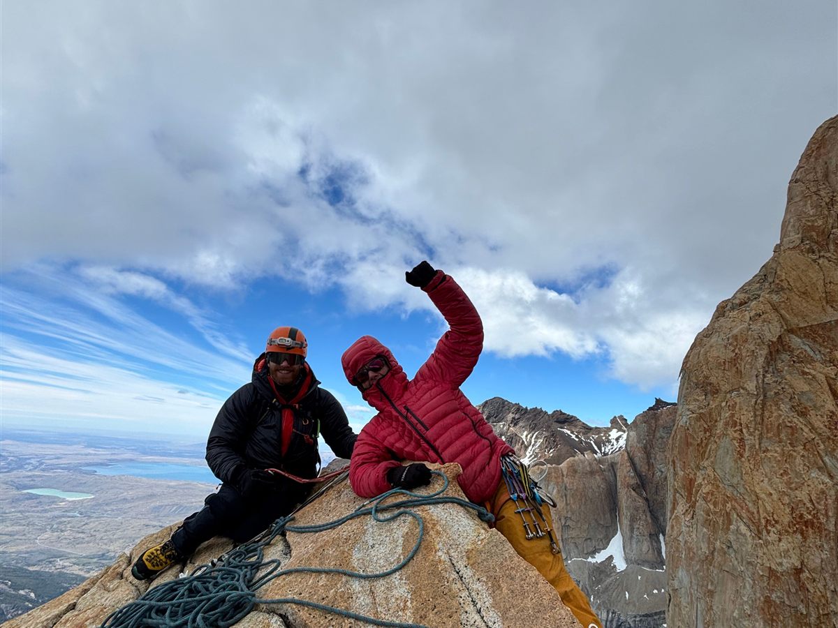 Guía y cliente celebrando en la cumbre de una torre de granito, Patagonia