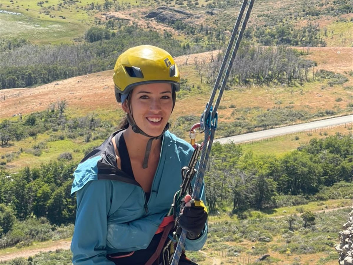 Práctica de rápel guiado sobre el valle patagónico durante un curso de escalada