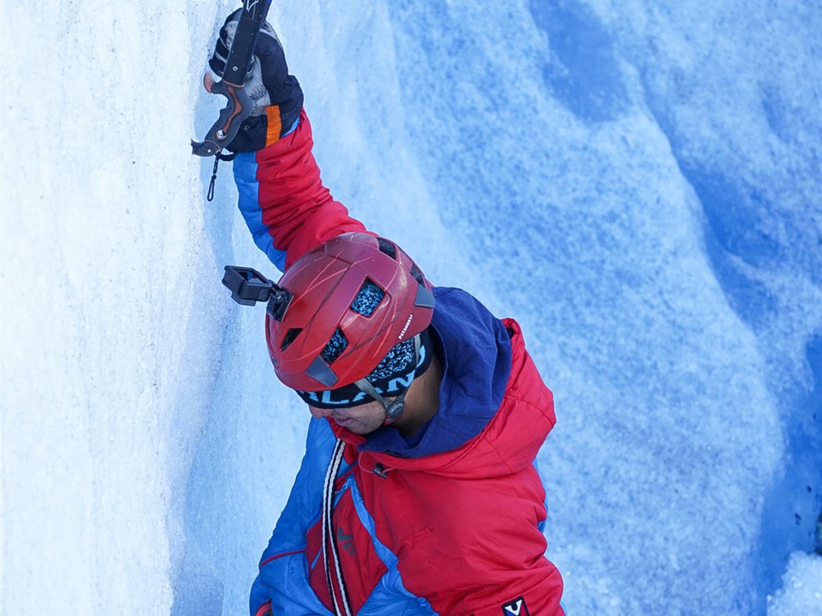Guía escalando pared de hielo glaciar con piolets, Patagonia