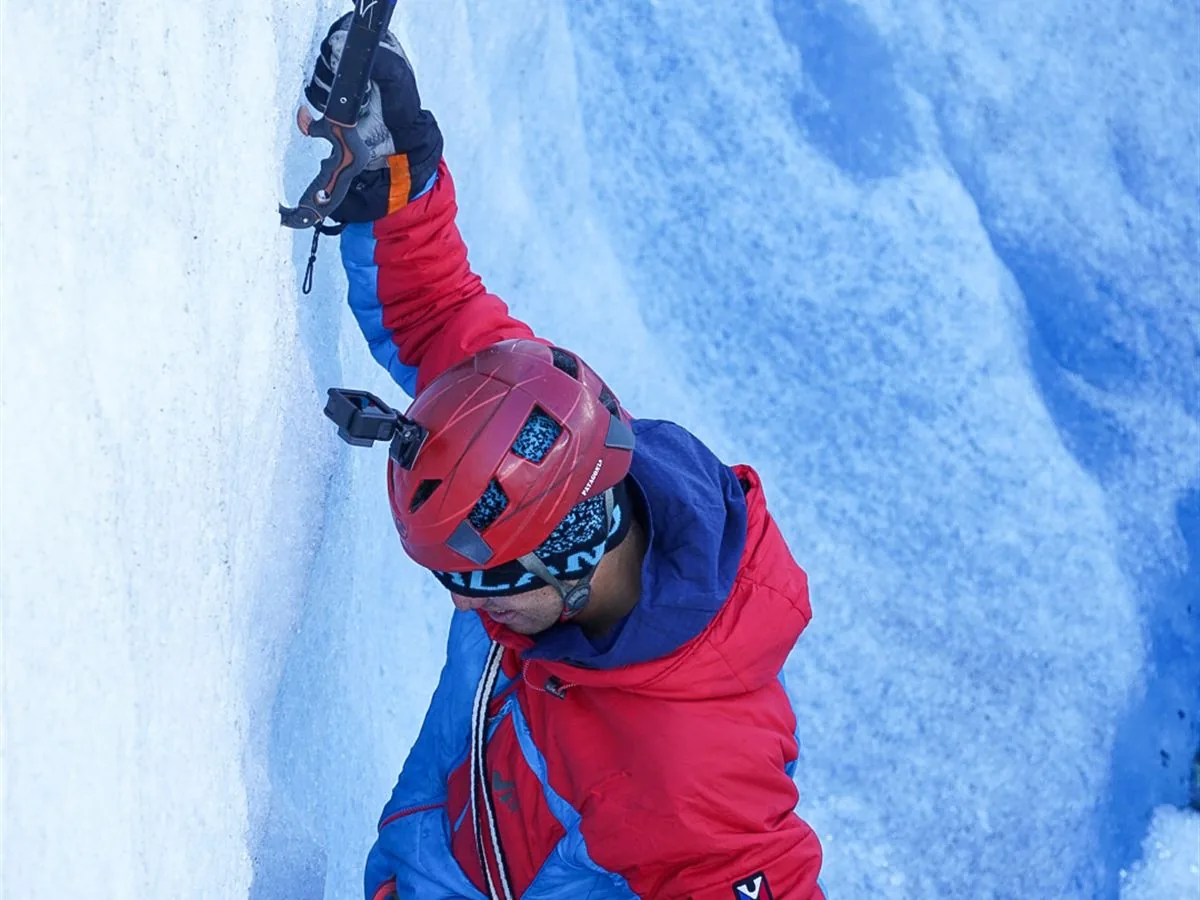 Guía escalando pared de hielo glaciar con piolets, Patagonia